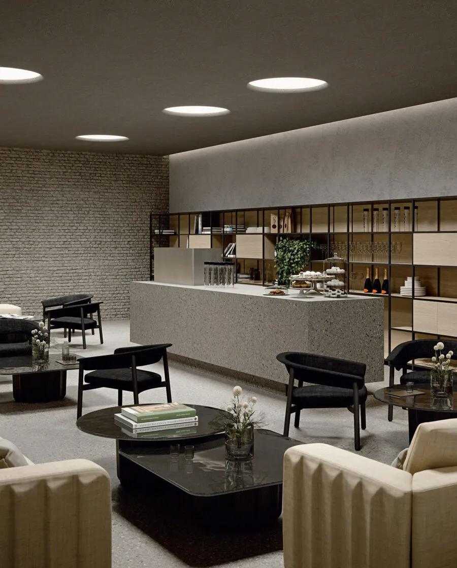 Lash wooden lounge chair in anthracite total look in a contemporary coffee shop lounge with black shelving and counter — Sabree Italian design