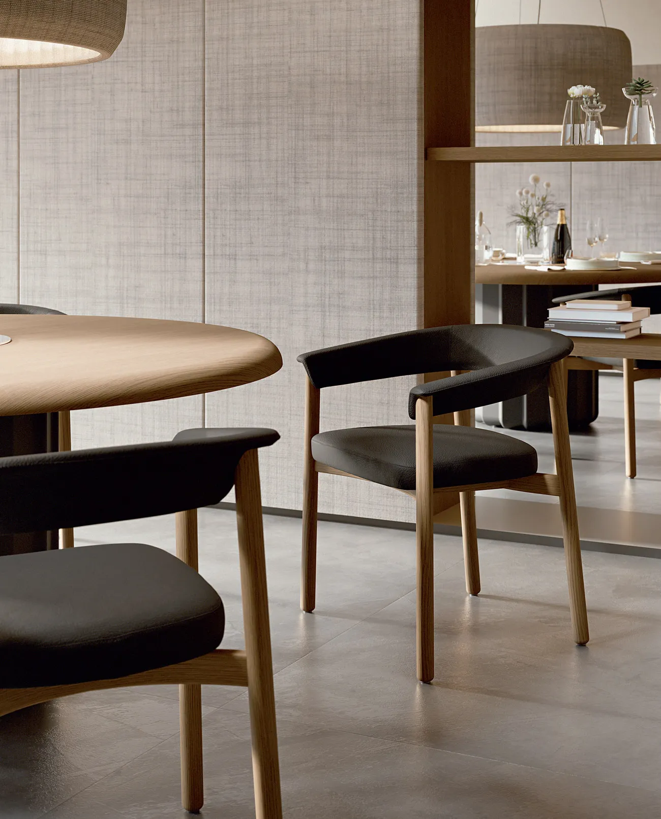 Lash wooden chair design in natural oak with black upholstered seat, detail view alongside a round oak table in a contemporary restaurant lounge — Sabree Italian design