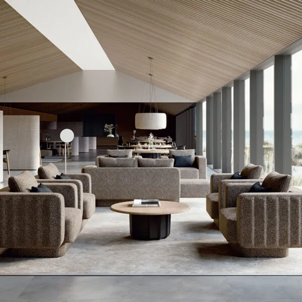 Sabree Italian modern furniture design collection: sofas, armchairs and coffee table in greige bouclé fabric in a resort lounge with wooden ceiling and seaside view — Frezza