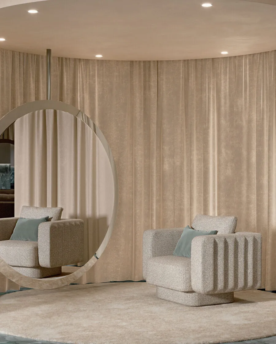 Sabree designer armchair in cream upholstery in a minimal living space with large round mirror and draped linen curtains — Italian design
