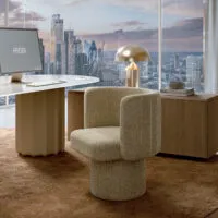 Sabree swivel armchair in sand bouclé upholstery alongside the Sabree table with brass lamp and New York skyline view — Italian design