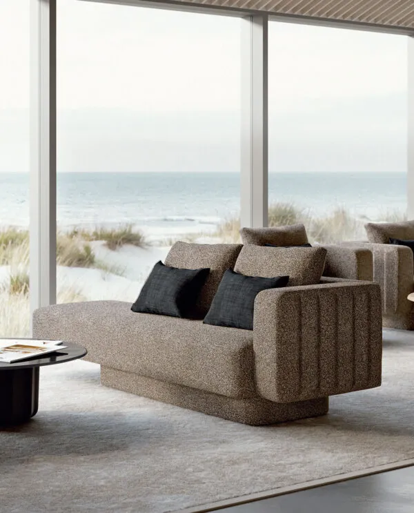 Sabree luxury sofa in taupe upholstery with blue cushions in a coastal living room with floor-to-ceiling windows and sea view — Italian design