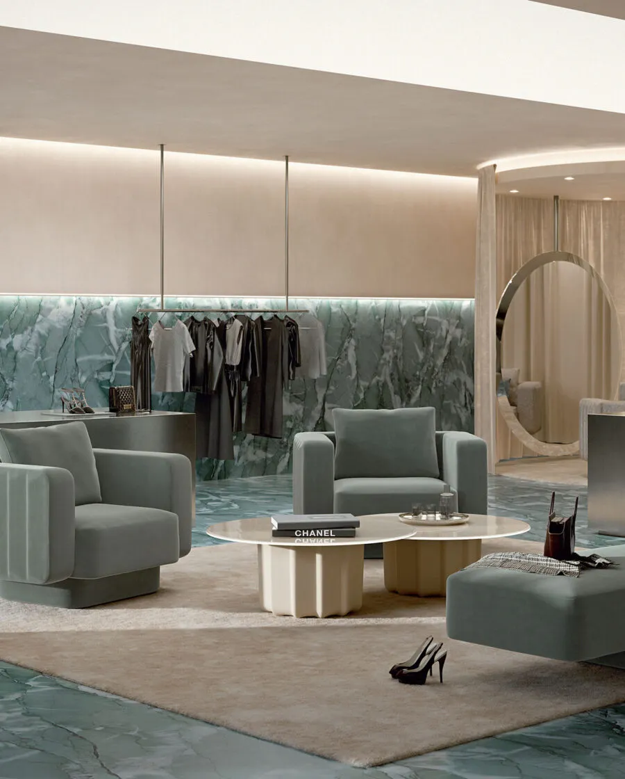 Sabree designer armchair in sage blue upholstery in a luxury boutique lounge with round mirror and green marble wall — Italian design