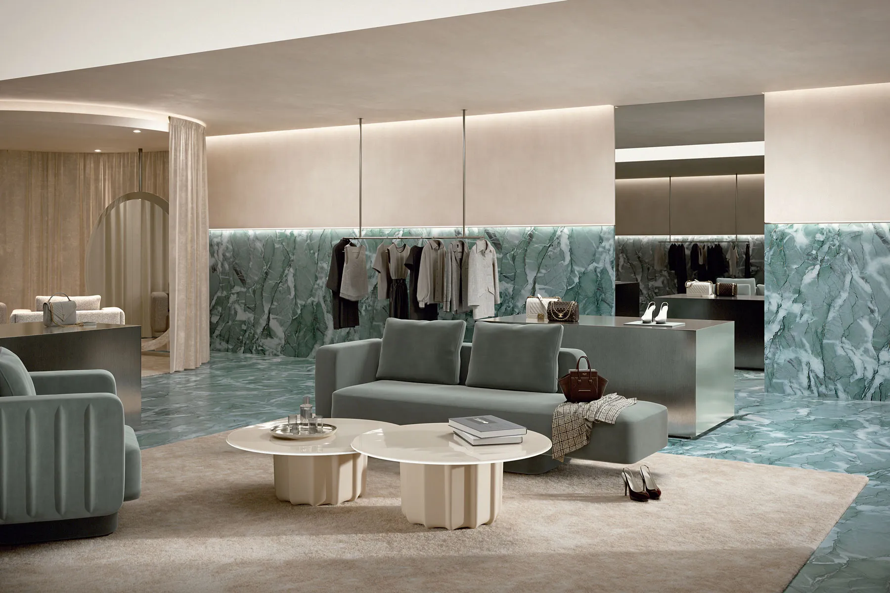 Sabree designer armchair and luxury sofa in light grey upholstery in a high-end fashion boutique with green marble wall — Italian design