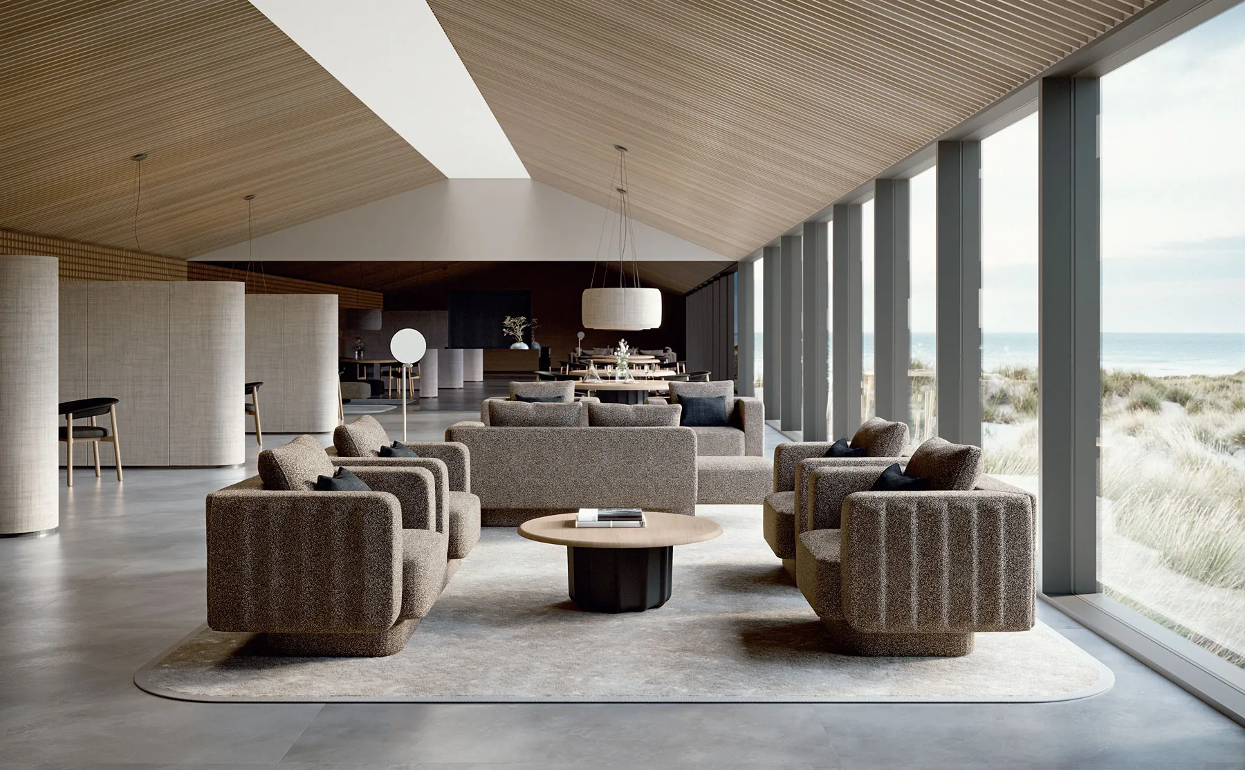 Sabree luxury sofa and designer armchair in taupe upholstery in a high-end hotel lounge with sloped wood ceiling and columns — Italian design