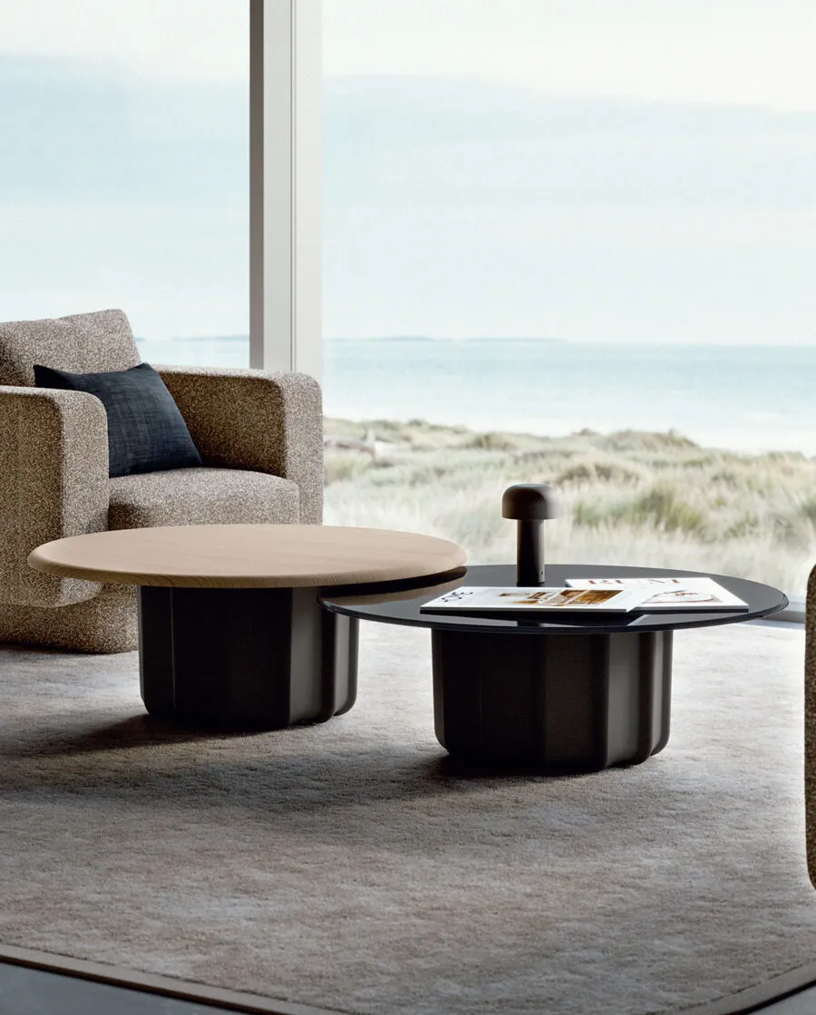 Sabree luxury coffee table with dark sculptural base and oak top in a coastal living room with dunes and sea view — Italian design