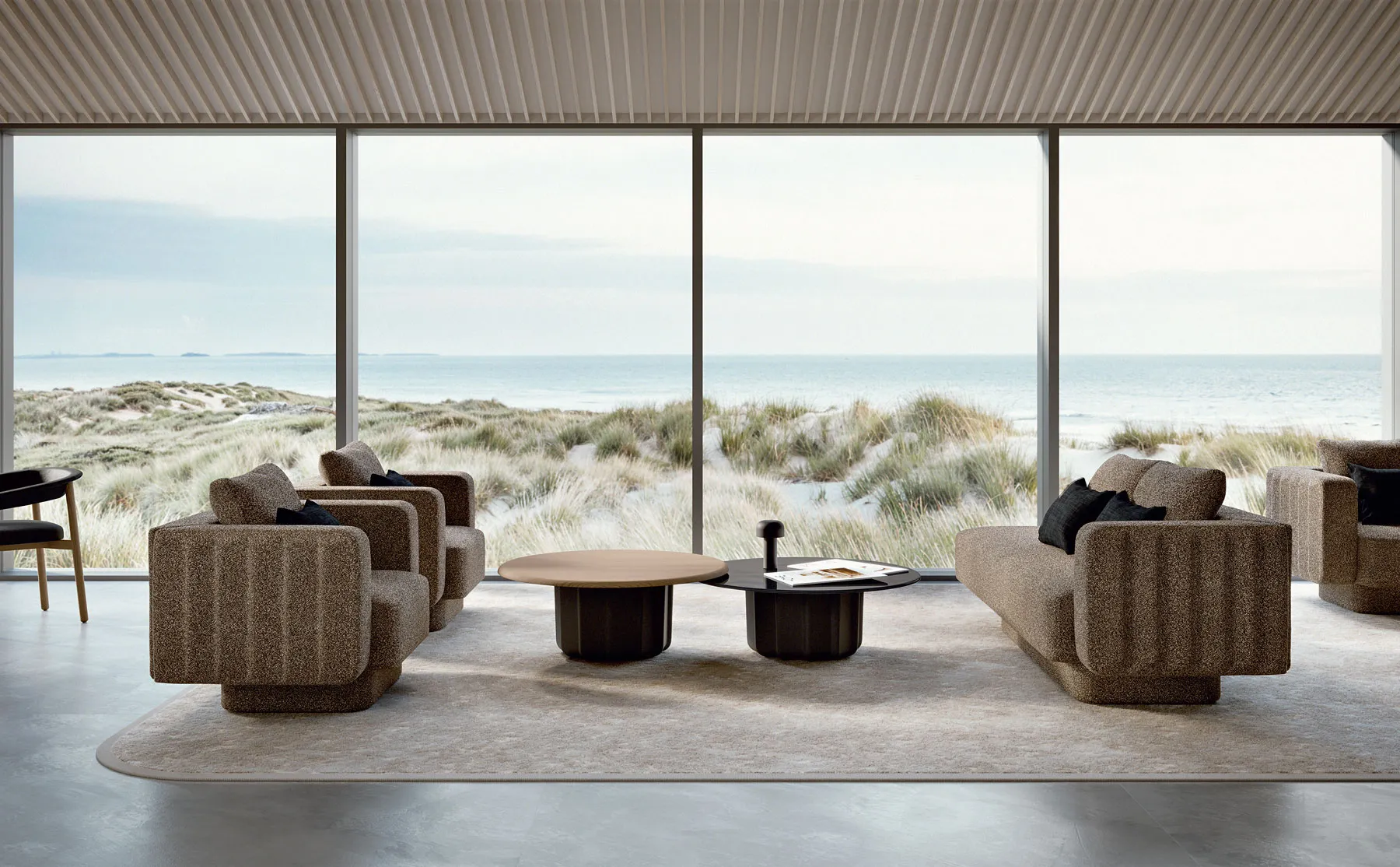 Sabree luxury coffee table with dark sculptural base and oak top in a coastal living room with sea view and upholstered armchairs — Italian design
