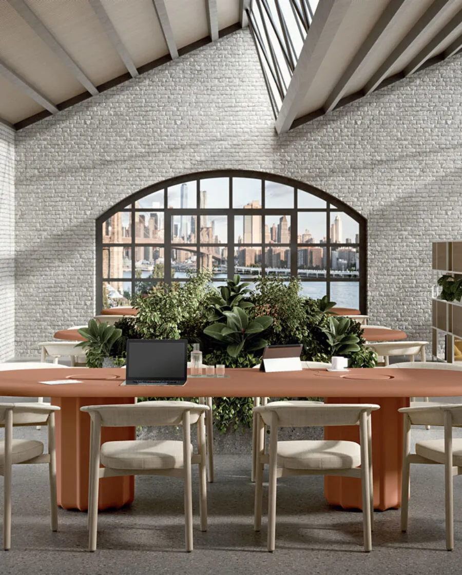 Sabree oval table design with terracotta bases and Lash chairs in an open space office with exposed brick walls and arched windows — Frezza contract